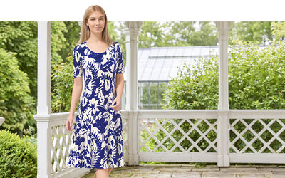 Dame in blau-weiss gemustertem Kleid auf einer Veranda